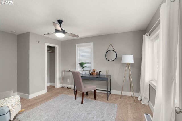 carpeted office featuring ceiling fan, plenty of natural light, and baseboards
