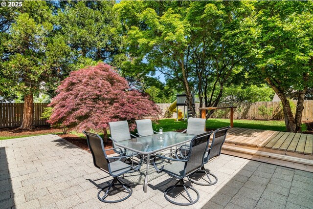 view of patio / terrace with outdoor dining space, a fenced backyard, and a deck