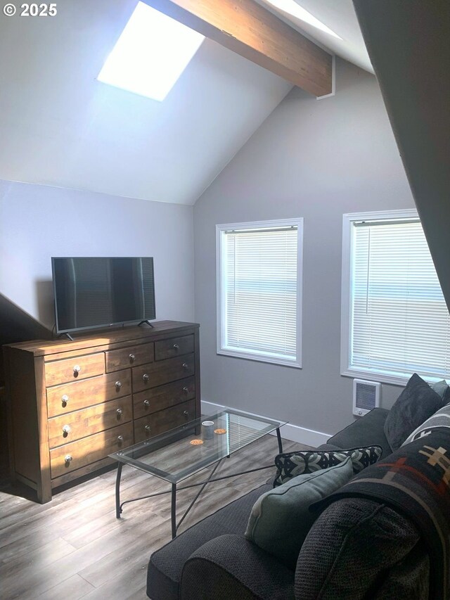 living room featuring wood finished floors and a skylight