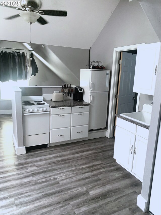 kitchen featuring white appliances, vaulted ceiling, white cabinets, dark wood-type flooring, and a ceiling fan