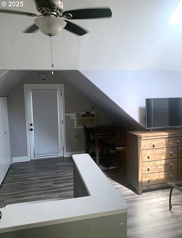 bonus room featuring wood finished floors, an AC wall unit, ceiling fan, and lofted ceiling