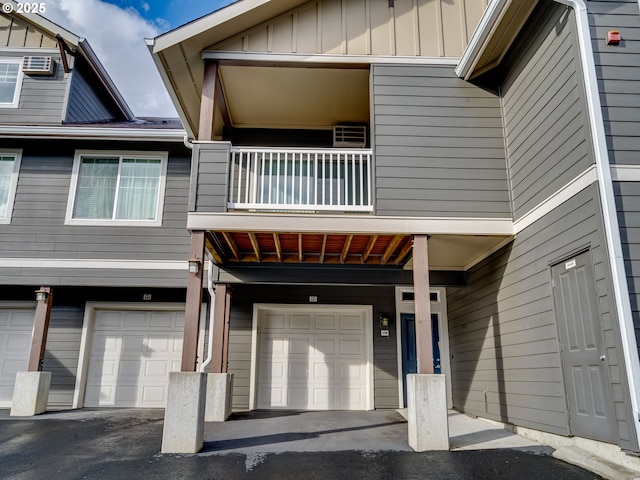 10800 SE 17th Cir Unit M141, Vancouver, WA 98664 - entrance to property featuring a balcony, board and batten siding, a garage, asphalt driveway, and cooling unit