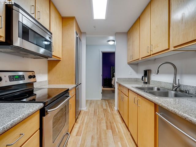 10800 SE 17th Cir Unit M141, Vancouver, WA 98664 - kitchen featuring stainless steel appliances, a sink, light wood finished floors, light brown cabinetry, and baseboards