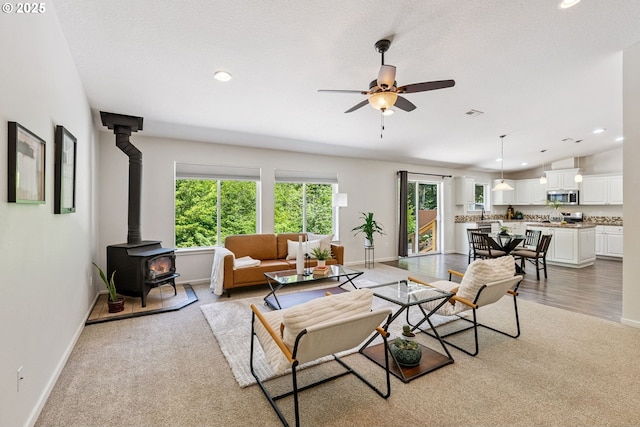 202 Edgewater Dr, Carson, WA 98610 - living area featuring a wood stove, light colored carpet, recessed lighting, and a ceiling fan