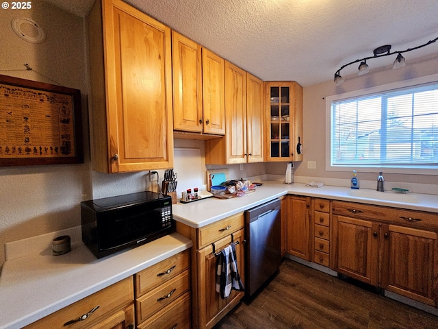 kitchen with glass insert cabinets, dishwasher, dark wood-style floors, a textured ceiling, and a sink