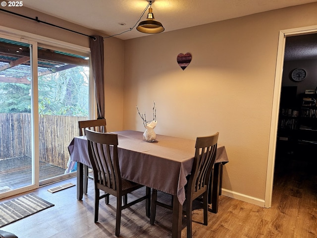 dining space featuring visible vents, baseboards, and light wood finished floors