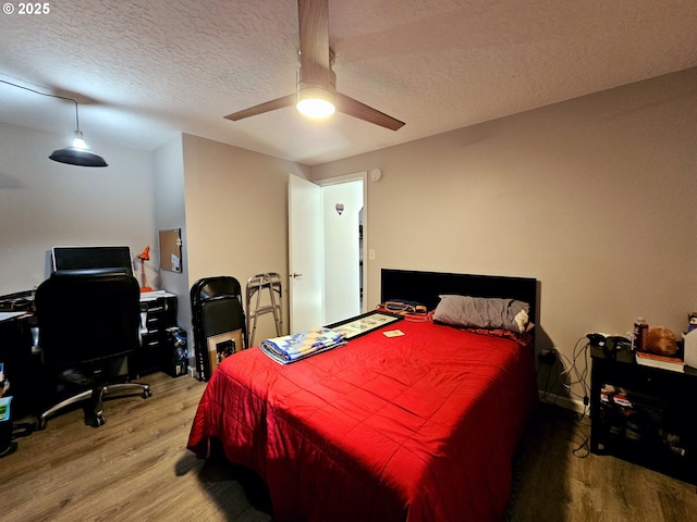 bedroom featuring ceiling fan, a textured ceiling, and wood finished floors