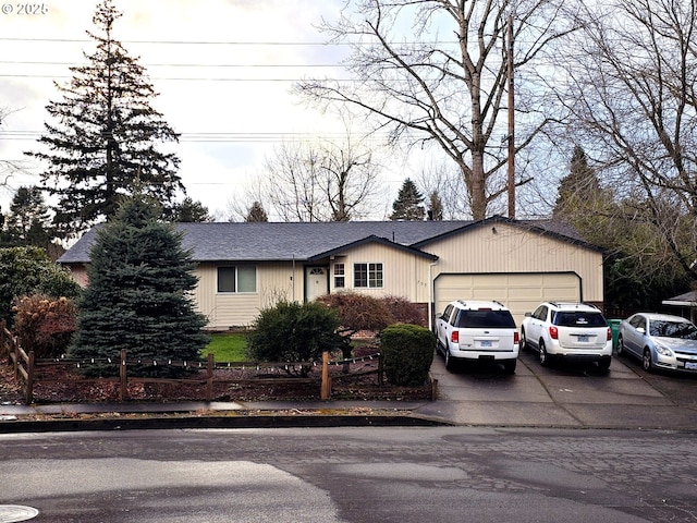 view of front of home with driveway, roof with shingles, a garage, and fence