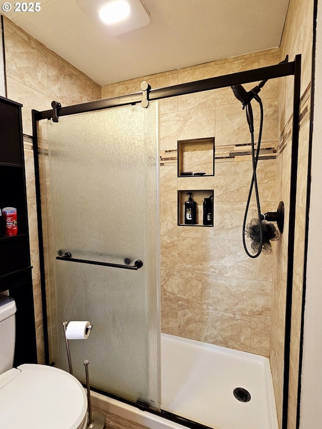 bathroom featuring a tile shower and toilet