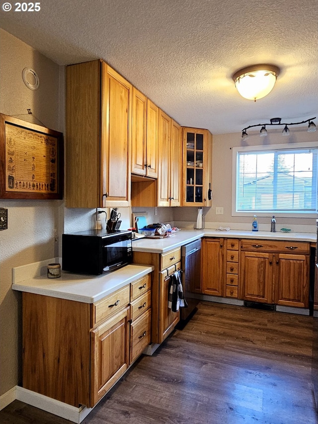 kitchen featuring dark wood-style floors, glass insert cabinets, black microwave, a textured ceiling, and stainless steel dishwasher