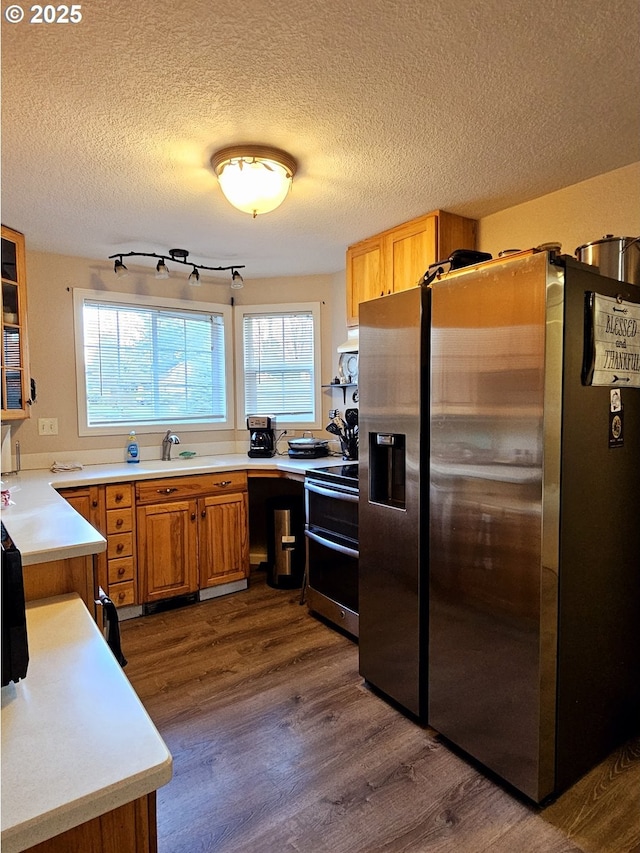 kitchen with dark wood-style floors, appliances with stainless steel finishes, a textured ceiling, and light countertops