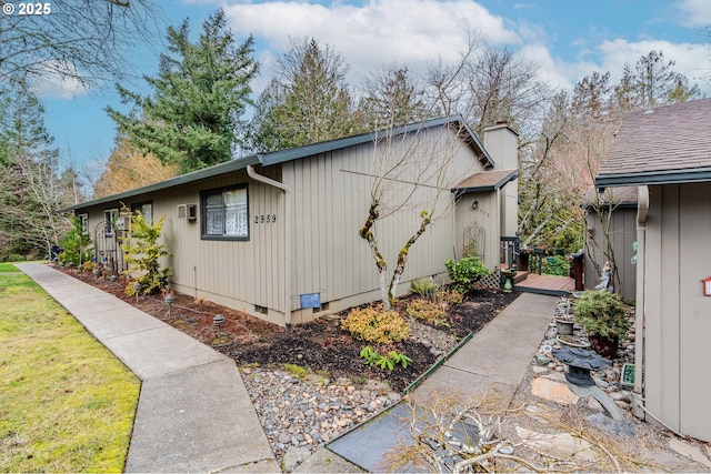 view of side of property featuring crawl space and a chimney