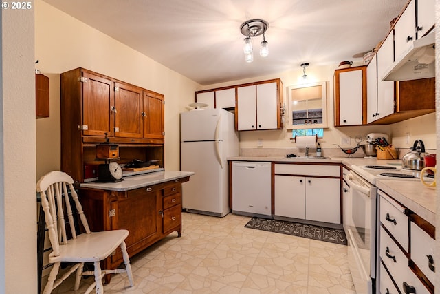 kitchen featuring white appliances, light countertops, a sink, and white cabinetry