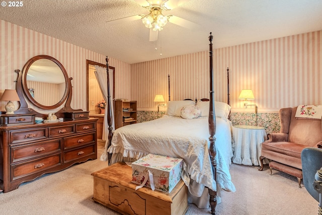 bedroom featuring light carpet, ceiling fan, a textured ceiling, and wallpapered walls