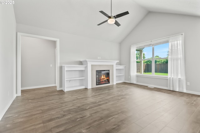 142 N 35th Pl, Cornelius, OR 97124 - unfurnished living room featuring ceiling fan, a glass covered fireplace, wood finished floors, high vaulted ceiling, and baseboards