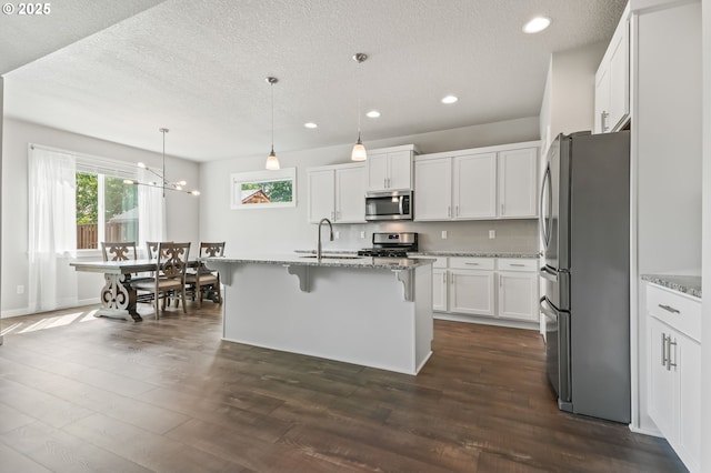 142 N 35th Pl, Cornelius, OR 97124 - kitchen featuring appliances with stainless steel finishes, light stone countertops, a textured ceiling, recessed lighting, and white cabinets