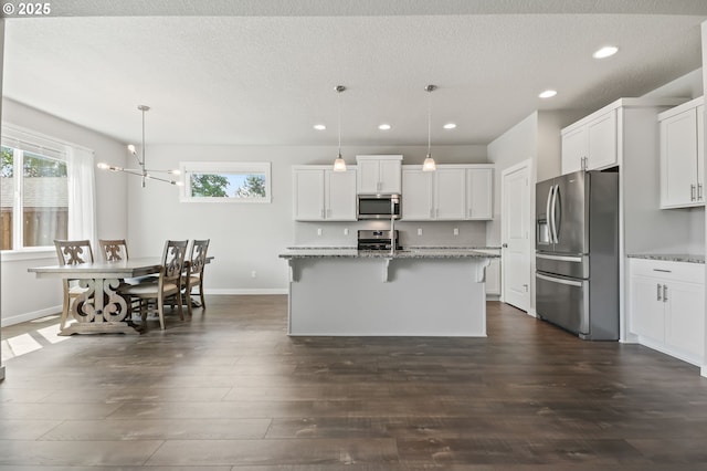 142 N 35th Pl, Cornelius, OR 97124 - kitchen featuring stainless steel appliances, recessed lighting, plenty of natural light, dark wood-style floors, and light stone counters