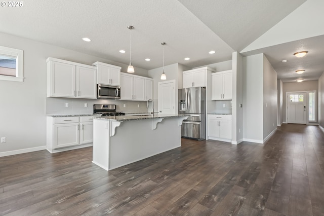 142 N 35th Pl, Cornelius, OR 97124 - kitchen with appliances with stainless steel finishes, white cabinetry, a breakfast bar area, light stone countertops, and a textured ceiling