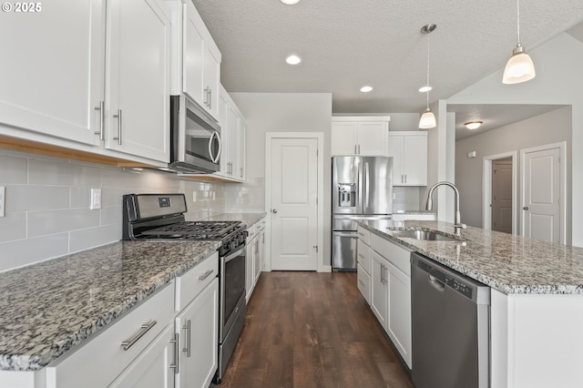 142 N 35th Pl, Cornelius, OR 97124 - kitchen featuring stainless steel appliances, a sink, dark wood finished floors, white cabinets, and a kitchen island with sink