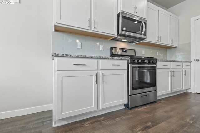 142 N 35th Pl, Cornelius, OR 97124 - kitchen with stainless steel appliances, decorative backsplash, dark wood-style floors, white cabinets, and light stone counters