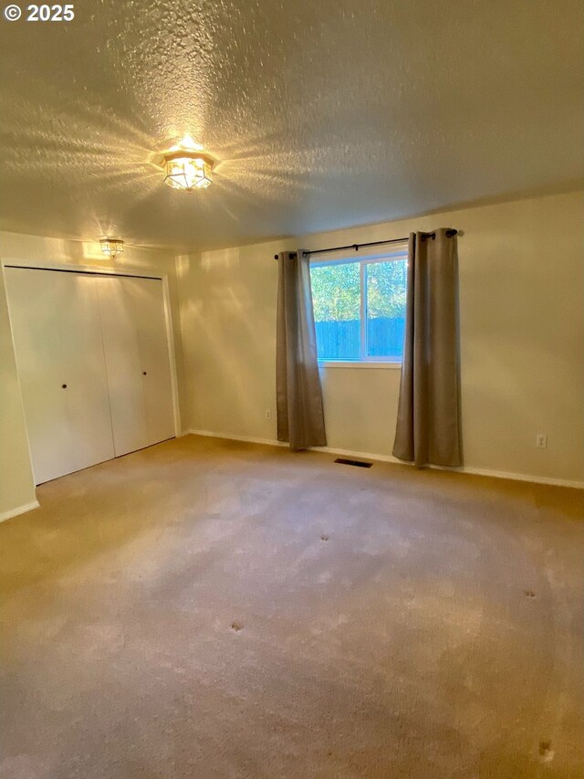 unfurnished bedroom with carpet and a textured ceiling