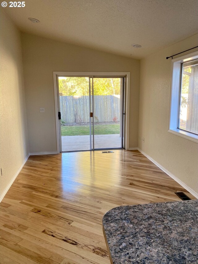 spare room featuring baseboards, light wood-style flooring, and visible vents