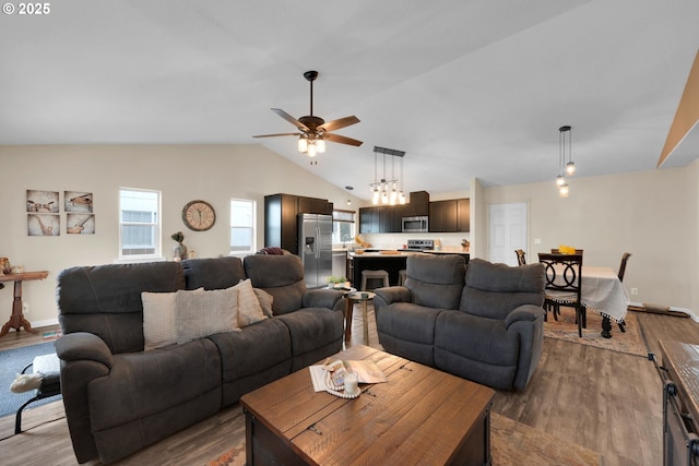 living area featuring a ceiling fan, vaulted ceiling, wood finished floors, and baseboards