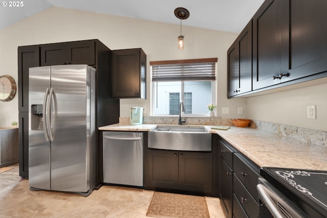 kitchen featuring stainless steel appliances, vaulted ceiling, a sink, decorative light fixtures, and light stone countertops