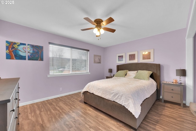 bedroom with wood finished floors, a ceiling fan, and baseboards