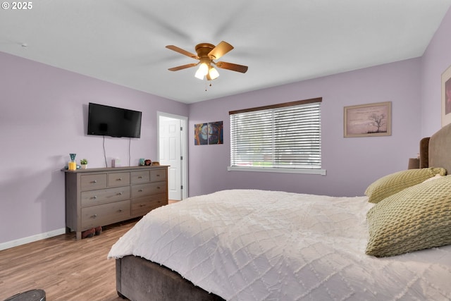 bedroom with ceiling fan, wood finished floors, and baseboards