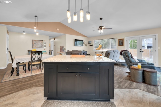 kitchen with ceiling fan, pendant lighting, open floor plan, french doors, and lofted ceiling