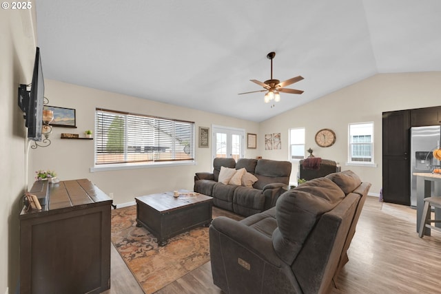 living room with ceiling fan, lofted ceiling, baseboards, and light wood-style flooring