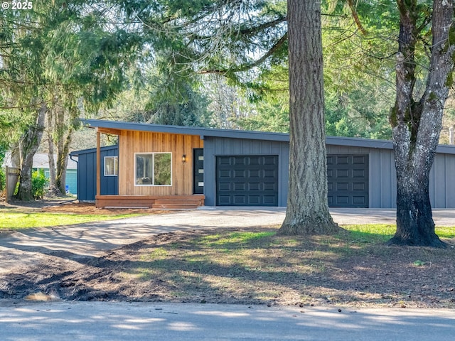 view of front of property with driveway, an attached garage, and board and batten siding