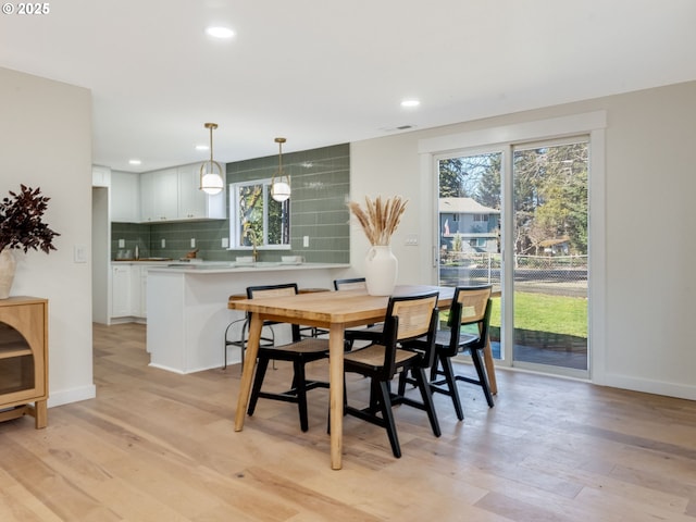 dining room with plenty of natural light, light wood-style flooring, baseboards, and recessed lighting