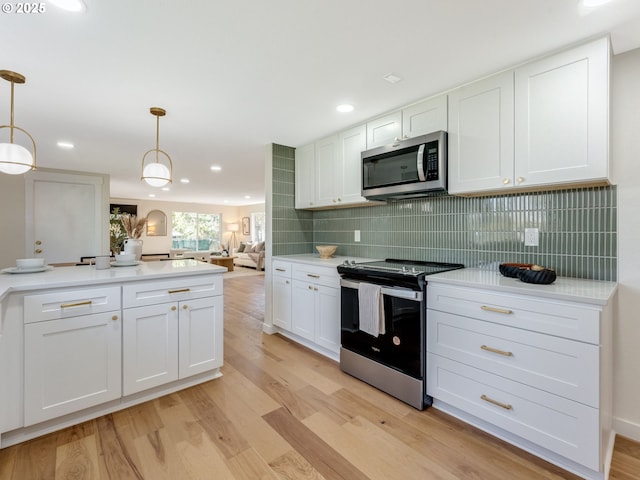 kitchen featuring stainless steel appliances, white cabinetry, light wood-style floors, and tasteful backsplash