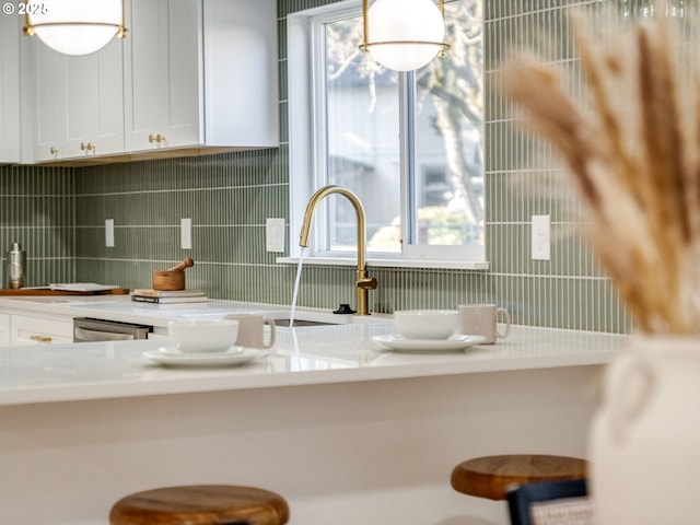 kitchen with light countertops, tasteful backsplash, and white cabinets