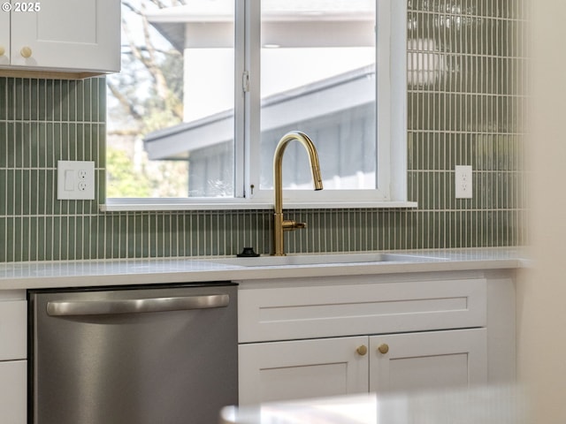 details with a sink, white cabinetry, light countertops, stainless steel dishwasher, and tasteful backsplash