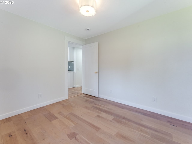 spare room featuring light wood finished floors and baseboards