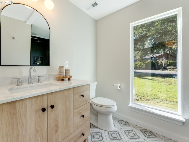 bathroom featuring toilet, baseboards, visible vents, and vanity