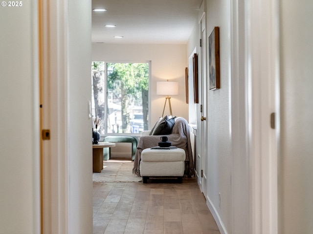 corridor with light wood finished floors and recessed lighting