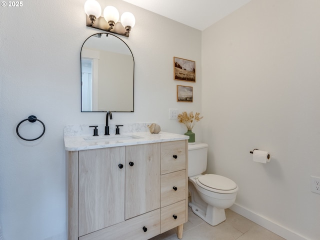 half bathroom featuring tile patterned flooring, baseboards, vanity, and toilet