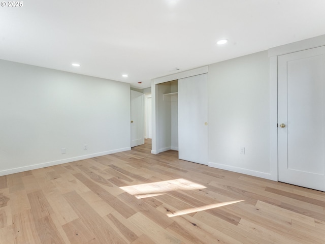 unfurnished bedroom featuring recessed lighting, light wood-type flooring, and baseboards