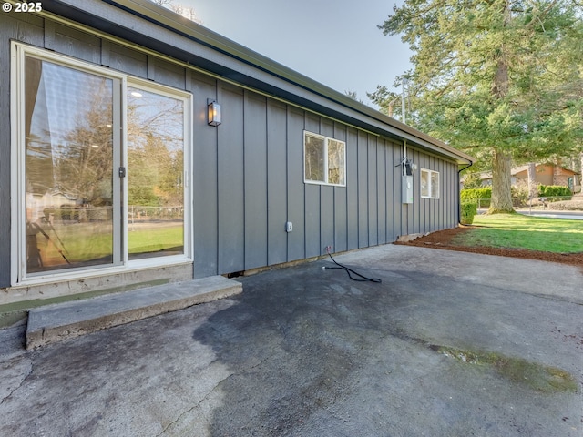 view of property exterior featuring board and batten siding and a patio