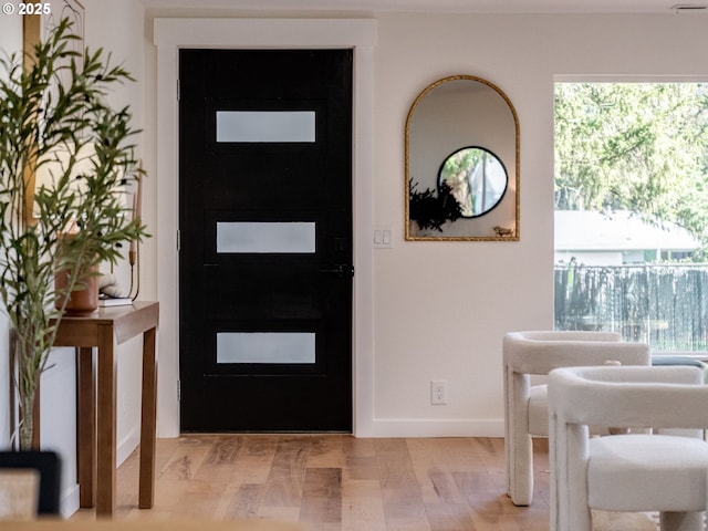 foyer entrance featuring light wood-type flooring and baseboards