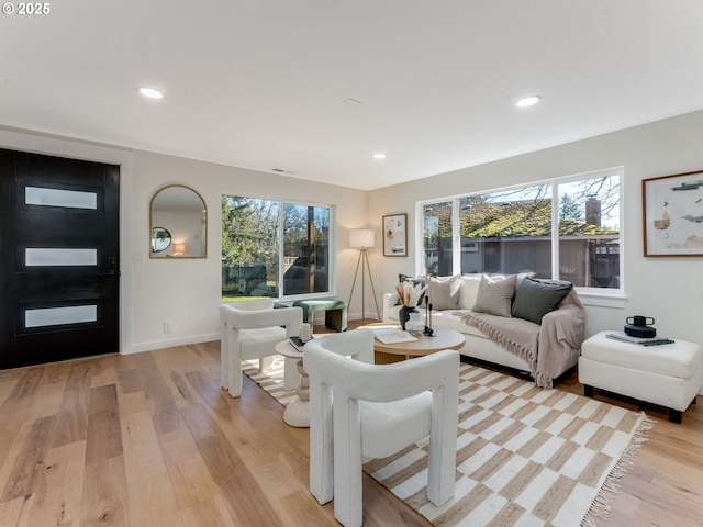 living area with light wood-style floors, baseboards, and recessed lighting