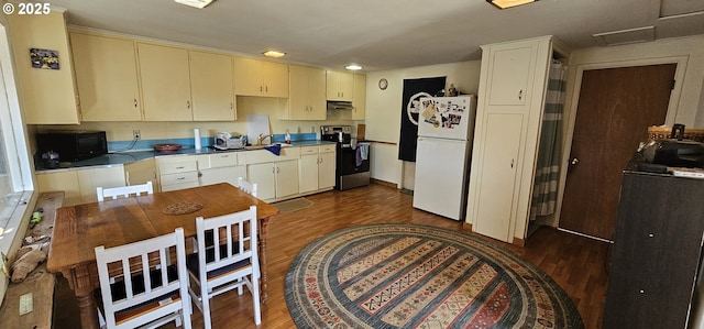33261 Ophir Rd, Gold Beach, OR 97444 - kitchen featuring stainless steel range with electric stovetop, freestanding refrigerator, dark wood-type flooring, black microwave, and cream cabinets