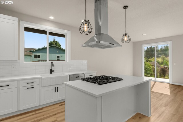 59787 Kimmell Ln, Saint Helens, OR 97051 - kitchen featuring wall chimney range hood, black gas cooktop, a sink, backsplash, and light wood finished floors