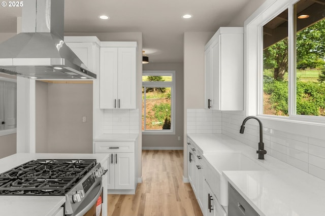 59787 Kimmell Ln, Saint Helens, OR 97051 - kitchen with stainless steel gas range, wall chimney range hood, light countertops, light wood-type flooring, and recessed lighting