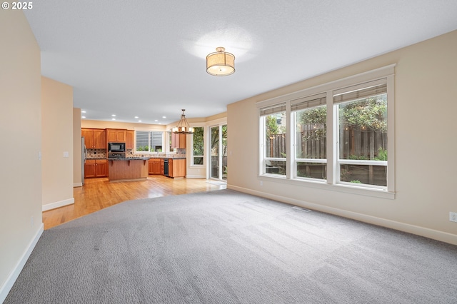 3578 NW Gerritz Ter, Portland, OR 97229 - unfurnished living room featuring light colored carpet, baseboards, a chandelier, recessed lighting, and light wood-type flooring