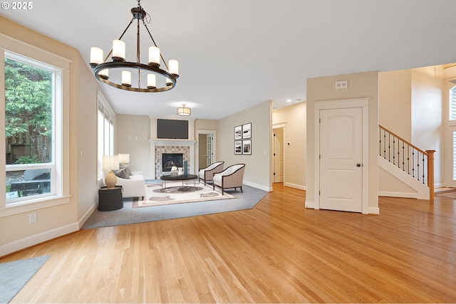 3578 NW Gerritz Ter, Portland, OR 97229 - living room with wood finished floors, baseboards, a chandelier, a fireplace, and stairs